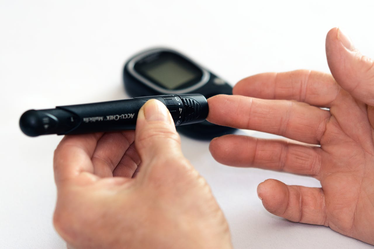 about-03 Close-up image of a person using a glucometer for diabetes management indoors.