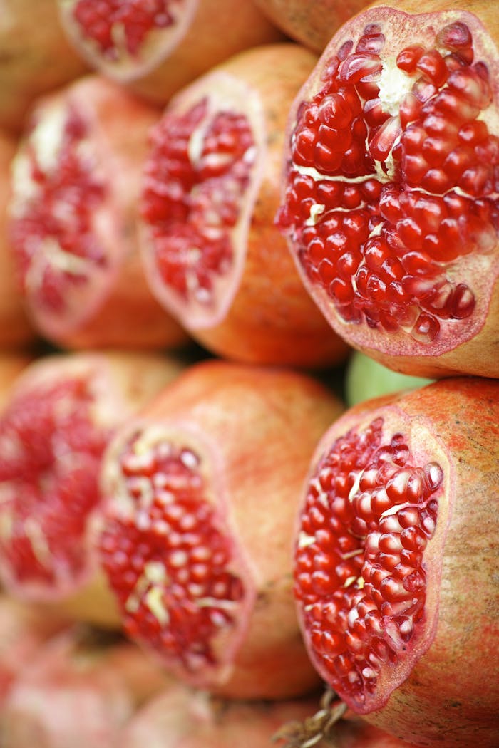 Fresh cut pomegranates showcasing vibrant red seeds, perfect for a healthy, nutritious breakfast.