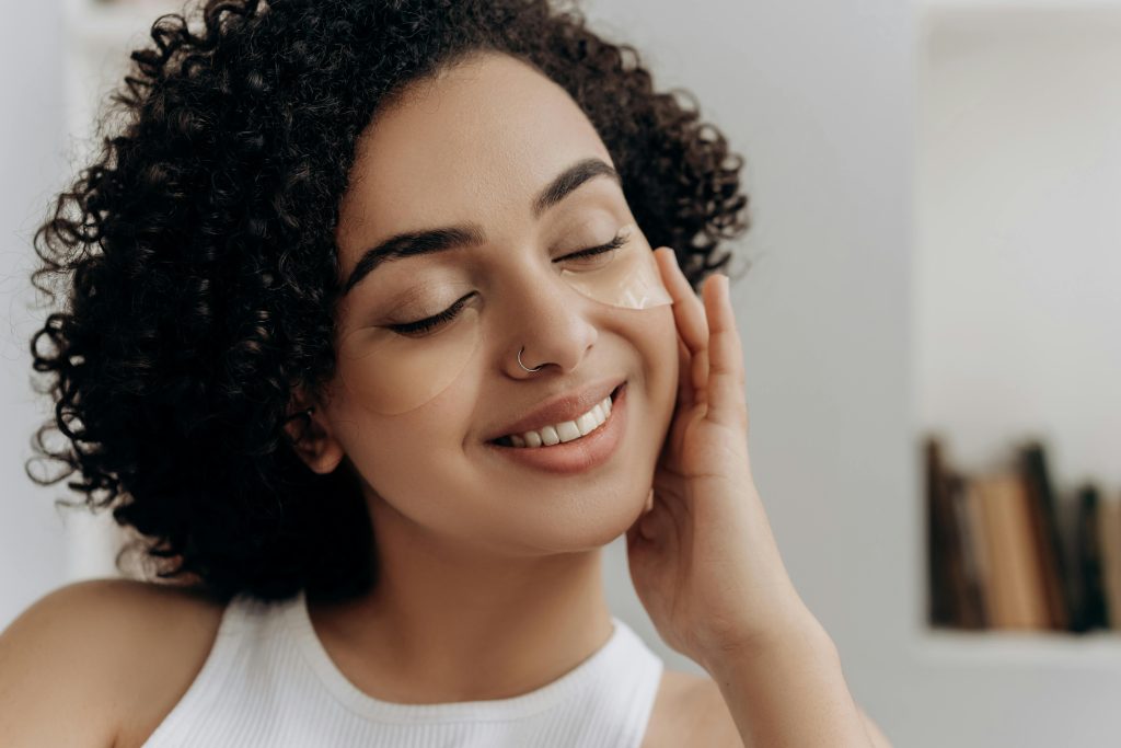 Woman applying retinol cream at night with calm, healthy skin and no redness.