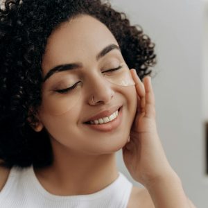 Woman applying retinol cream at night with calm, healthy skin and no redness.